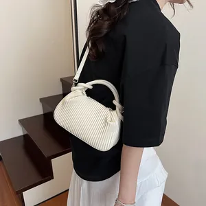 Détail d'un sac nuage plissé blanc avec poignée torsadée et bandoulière amovible