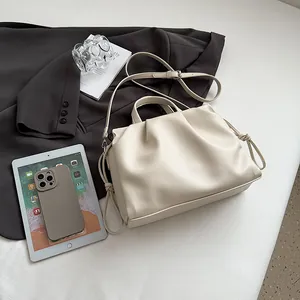 Detail of cream pleated tote bag with lychee texture and adjustable shoulder strap
