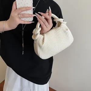 Vue détaillée du sac à main plissé blanc cassé avec poignée nouée et anneaux métalliques