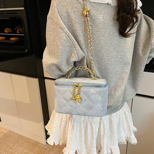 Détails du sac vanité matelassé bleu clair avec breloques rose dorées et bandoulière