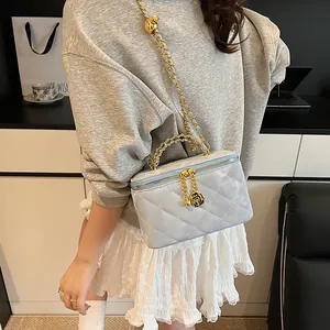 Détails du sac matelassé bleu clair avec pendentif rose dorée et poignée sur le dessus