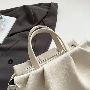 Detailed top view of the cream pleated tote bag showing lychee grain leather texture