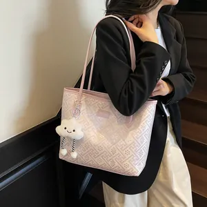 Dettaglio della borsa tote a motivi rosa con un simpatico ciondolo a nuvola sulla tracolla