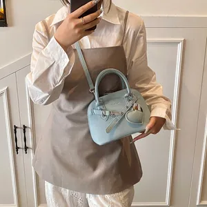 Détail du cuir bleu clair à motif litchi avec pendentif coeur et gaufrage chicbag