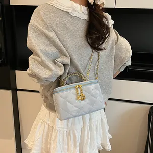 Détails du mini sac matelassé bleu clair avec chaîne dorée et pendentif rose