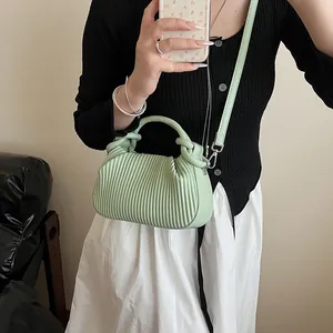 Détail du sac à main plissé vert menthe montrant la texture et la bandoulière réglable