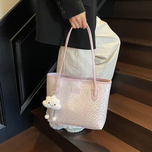 Dettaglio della borsa rosa con motivi geometrici e ciondolo a nuvola di peluche