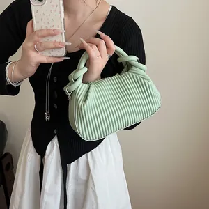 Détail du sac à main vert menthe plissé avec poignée nouée et texture en cuir PU souple