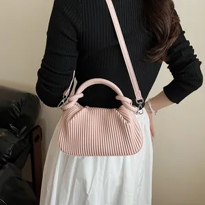 Détails du sac à main plissé rose montrant les textures verticales et les boucles argent
