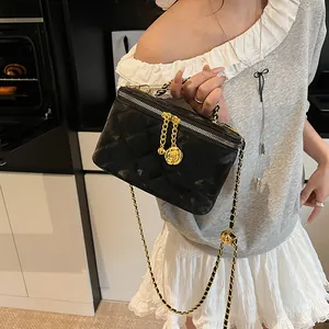 Détail de la trousse de maquillage matelassée avec chaîne dorée et pendentif rose