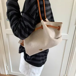 Canvas tote bag with brown leather straps shown on a model for scale and fit