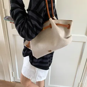 Canvas tote bag with brown leather straps shown on model for size and style reference