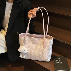 Vista dettagliata della borsa tote rosa geometrica con ciondolo a nuvola e logo