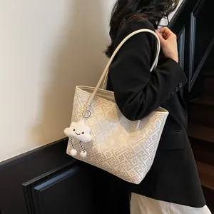 Dettaglio della grande borsa tote con motivi geometrici e ciondolo a nuvola bianca