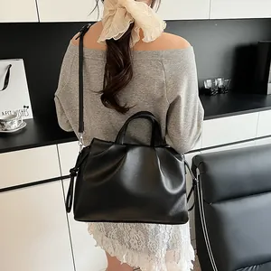 Detailed view of the large pleated black cloud bag shown on model for daily commuting