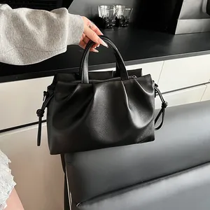 Detail of black pleated cloud bag showing pebbled leather texture and drawstring sides