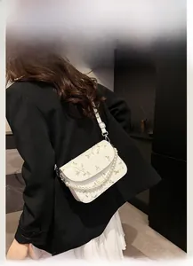 Rückansicht von Model mit weißer Spitzen-Sticktasche mit Perlen-Griff und langem Trageriemen