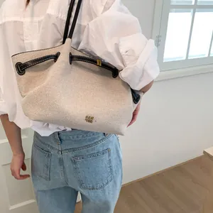 Detailed shot of oversized canvas tote bag in off-white with black leather handles