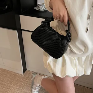 Gros plan détaillé d'un sac à main noir plissé avec une poignée nouée pour femmes
