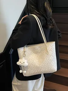 Grande borsa tote crema con motivi floreali a rilievo e ciondolo nuvola su modella