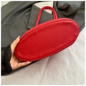 Close-up of red lychee texture leather bucket bag with dual handles for daily commute