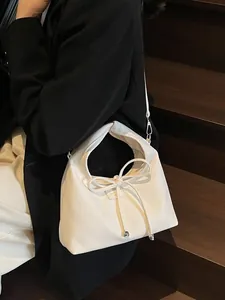 Elegant white litchi pattern leather handbag with a bow detail in a modern trapezoid shape