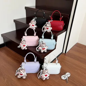 Détail de mini sacs carrés avec poignées à nœuds et pendentifs ours en peluche mignons