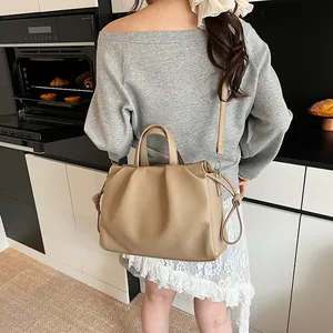 Detail of khaki pleated dumpling bag showing leather texture and silver buckle strap