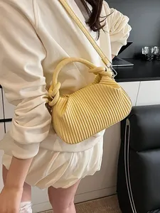 Sac à bandoulière jaune pâle plissé avec texture verticale et détails argentés