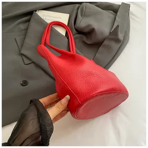 Top-down view of red bucket bag showing pebbled leather texture and integrated handle