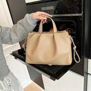 Detail view of khaki pleated cloud bag showing soft leather texture and stylish knot strap