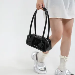 Detail of a black patent leather bowling bag with silver zipper and long handle