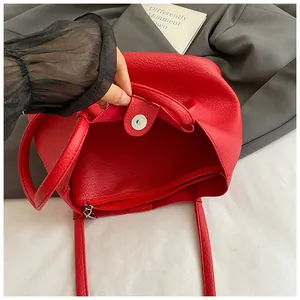 Detail view of red lychee pattern tote bag showing metal magnetic clasp and inner zip pocket