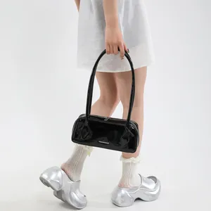 Detail of black glossy patent leather bowling bag with metallic logo and zipper closure