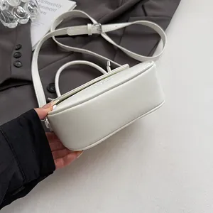 Détail d'un sac à bandoulière en cuir blanc avec finitions argentées et sangle