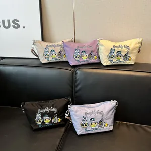 Detail of five colorful nylon crossbody bags with Naughty kitty embroidery on a leather sofa
