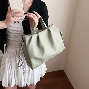 Close-up of sage green pleated cloud bag featuring lychee texture and side drawstring