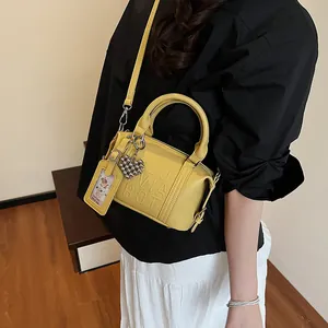 Chic yellow cylinder crossbody bag with embossed letters and heart charm for women