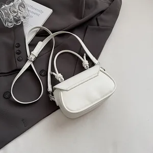 Vue détaillée du mini sac en cuir blanc avec poignée nouée et boucles argentées chic