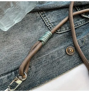 Detailed macro shot of vintage brown woven strap with mint green knots and silver metal clasp