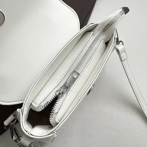 Détail du sac en cuir PU blanc montrant la fermeture éclair argentée et la doublure