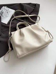 Minimalist beige pleated cloud tote bag in lychee pattern leather with knotted details