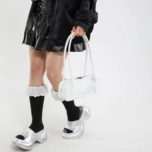 White leather handbag with shoulder strap and metal buckle shoes on fashion model