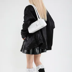 Detailed back view of a white rectangular baguette shoulder bag on a model