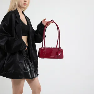Detail of burgundy patent leather baguette bag with silver hardware and fashion text