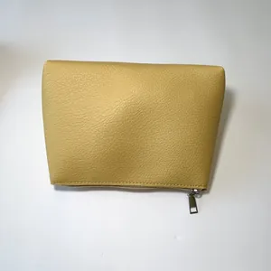 Close-up of a yellow litchi texture tote bag featuring a silver metal top zipper