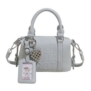 Light blue pebbled leather Boston bag with embossed letters and heart charm detail
