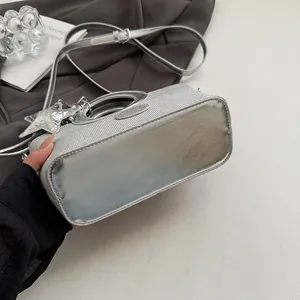 Détail du sac seau argenté montrant la texture tissée et la base miroir brillante