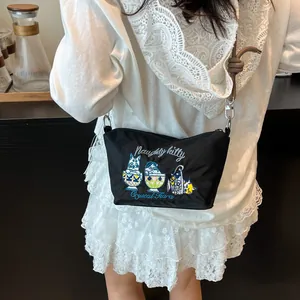 Detail of black nylon crossbody bag with cute cat embroidery and brown knotted strap