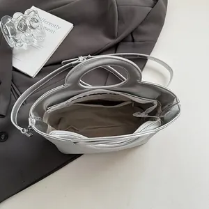 Détail intérieur du sac seau argenté avec compartiments et poignée ronde
